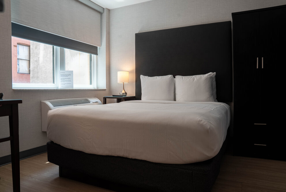 a bed with a black headboard and white sheets