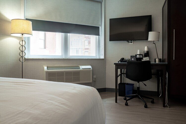 a room with a bed and a desk and a television