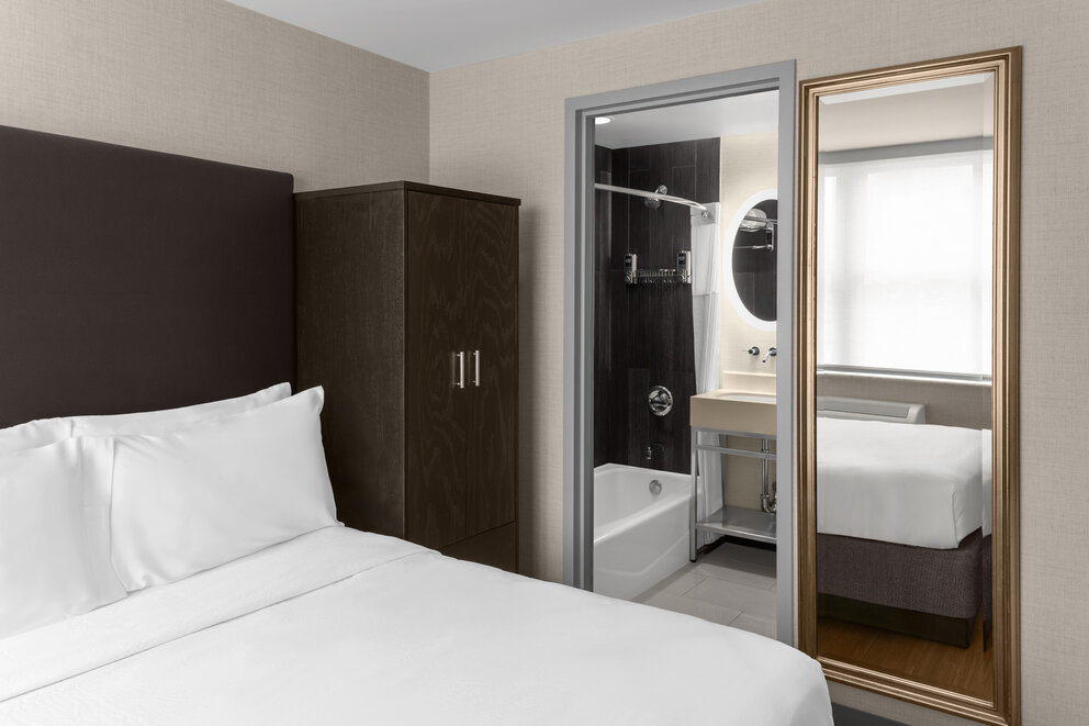 a room with a mirror and a bed