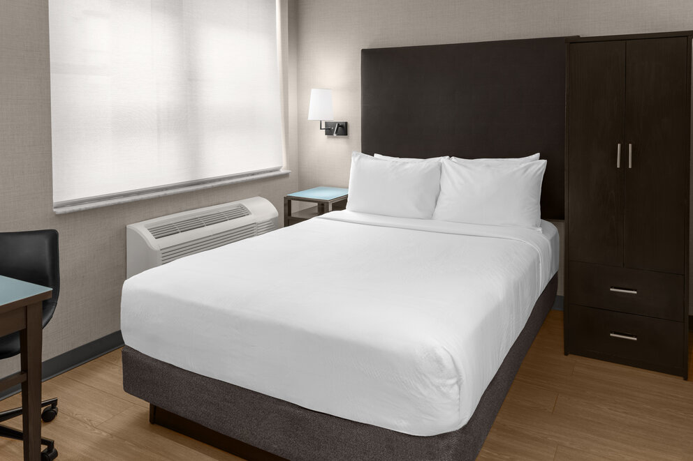 a bed with white sheets and a heater