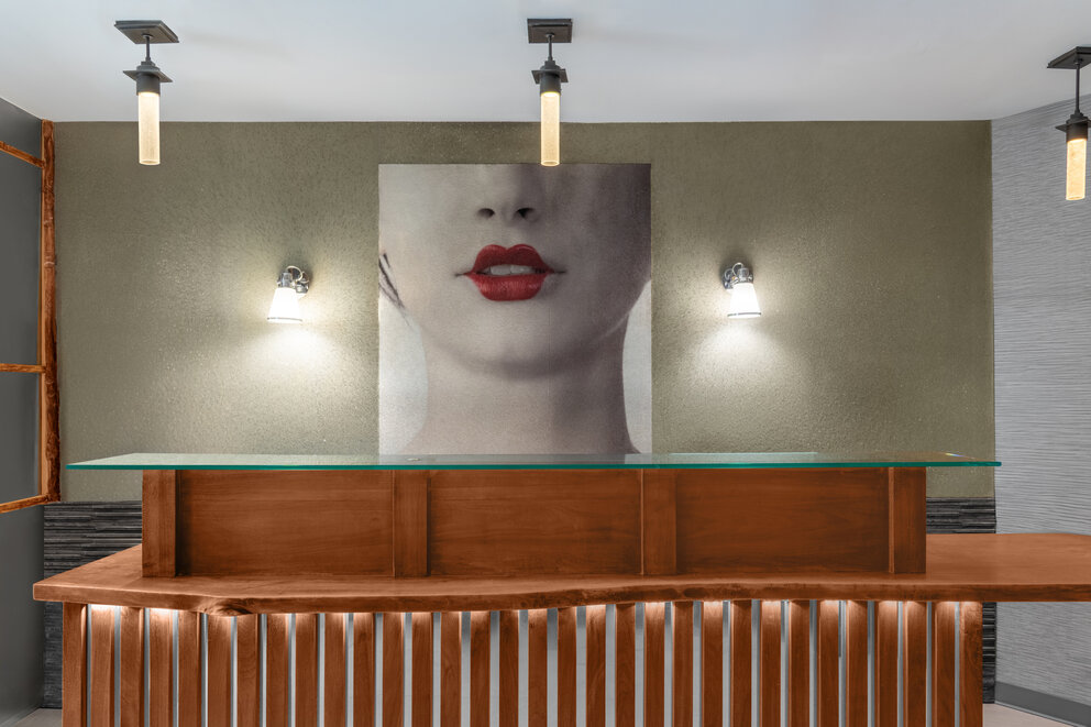 a painting of a womans face on a wall with lights