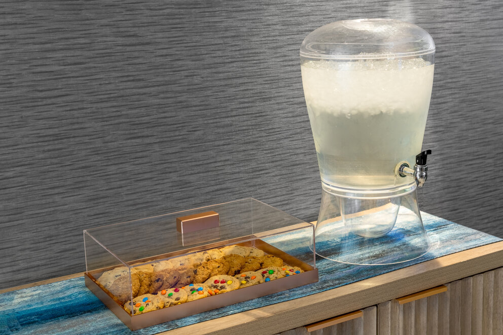 a glass container with a drink dispenser and a cookie in a container